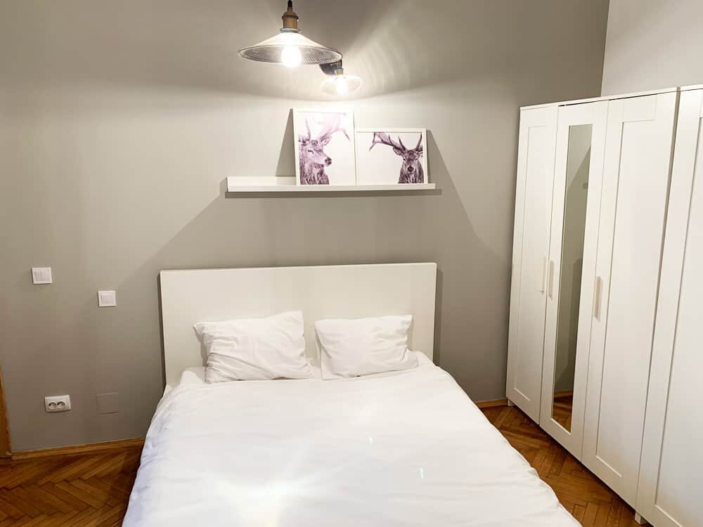 bedroom with grey wall and white pictures